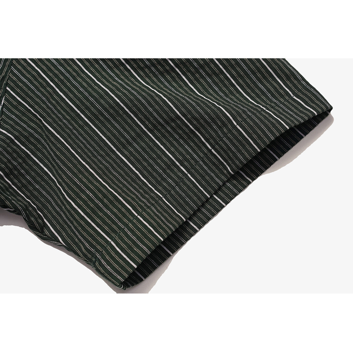 Close-up of the hem of a dark green shirt with narrow white stripes.