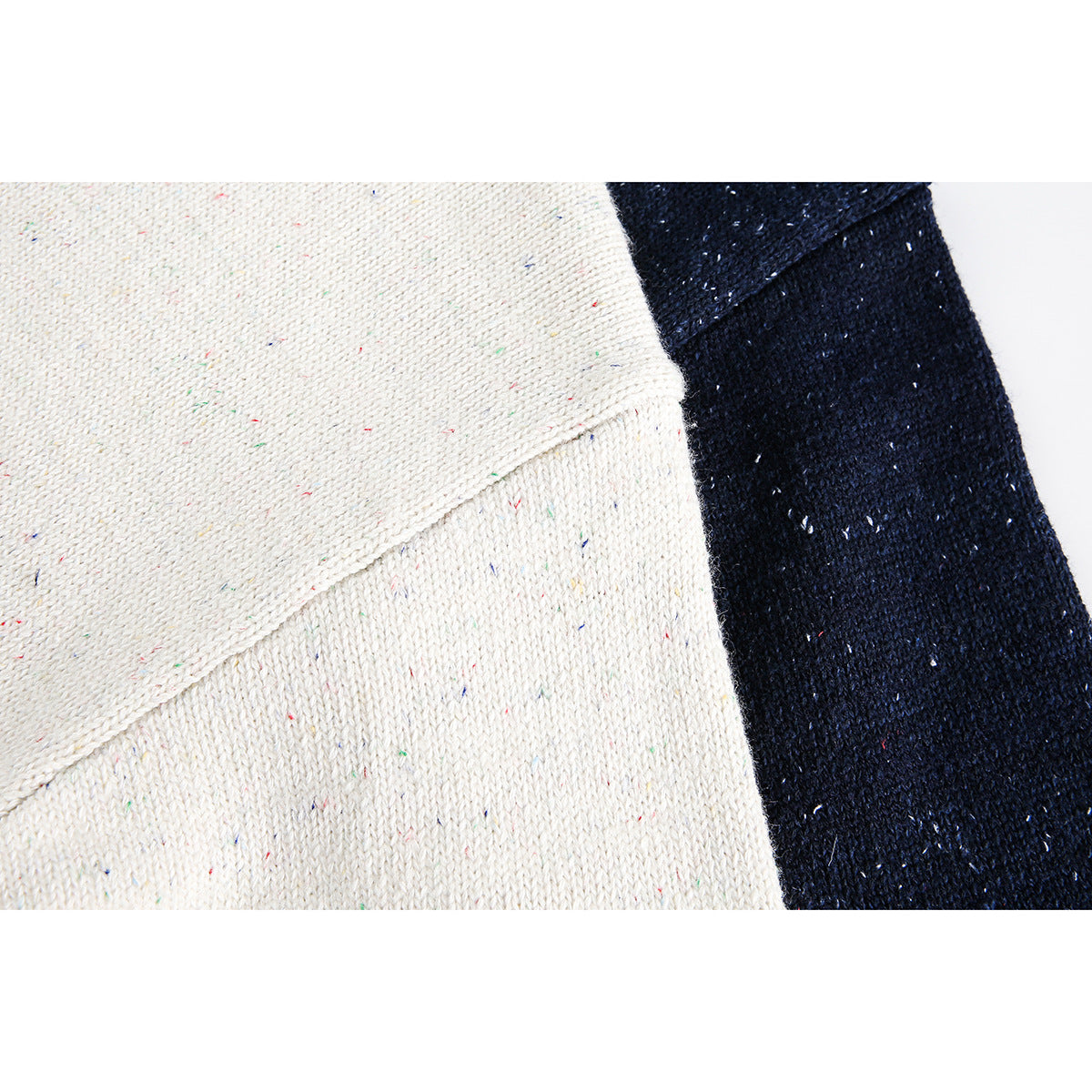 Close-up of cream and navy speckled knit fabric with a diagonal seam.