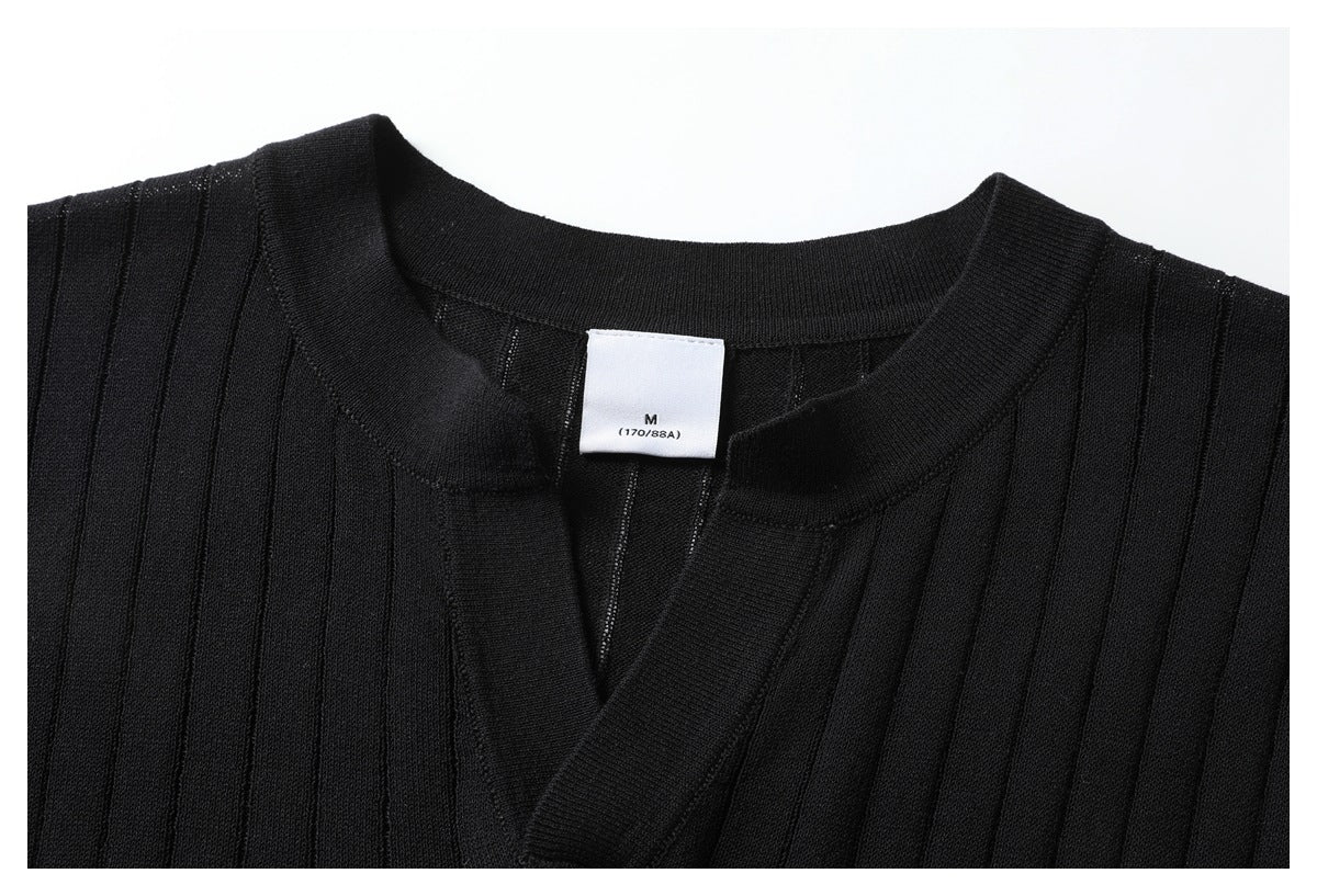 Close-up of a black ribbed knit top showing its round neckline, V-shaped opening, and size label.