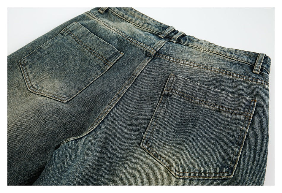 Angled back view of faded blue jeans with two patch pockets, belt loops and contrast stitching.