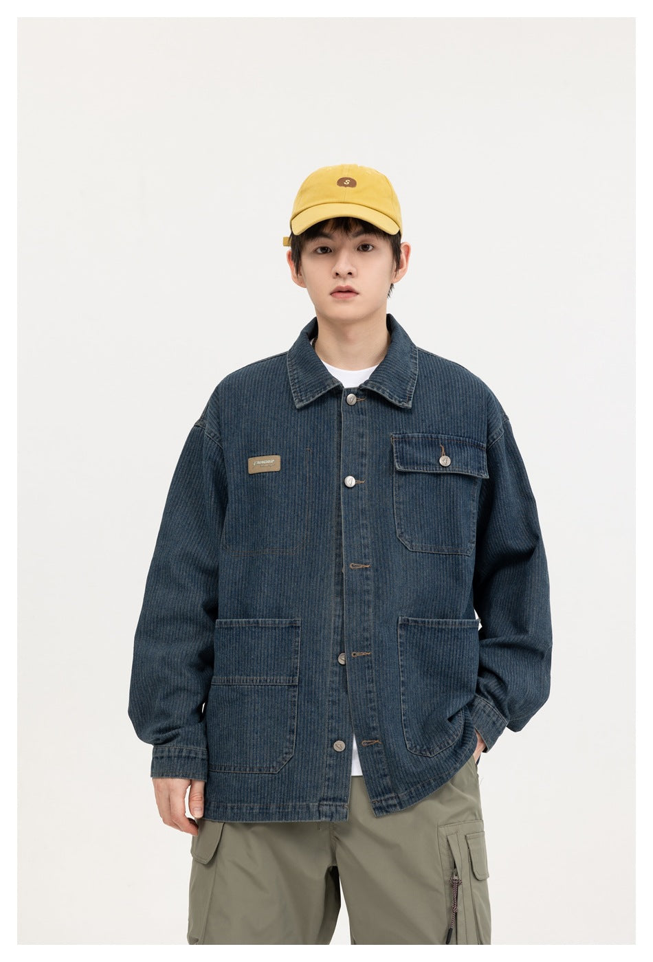 Model wearing a dark blue denim work jacket with a button front and multiple pockets, shown from the front.