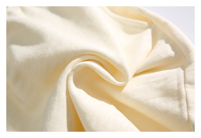Extreme close-up of cream fabric folded to show its fine ribbed texture.