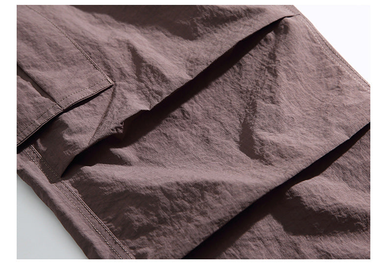 Close-up of the mauve pants' large flap cargo pocket and stitched seams.