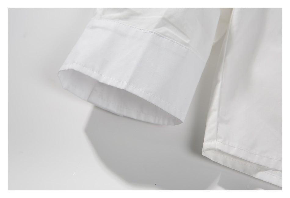 Close-up of the white jacket’s sleeve cuff and lower hem stitching.