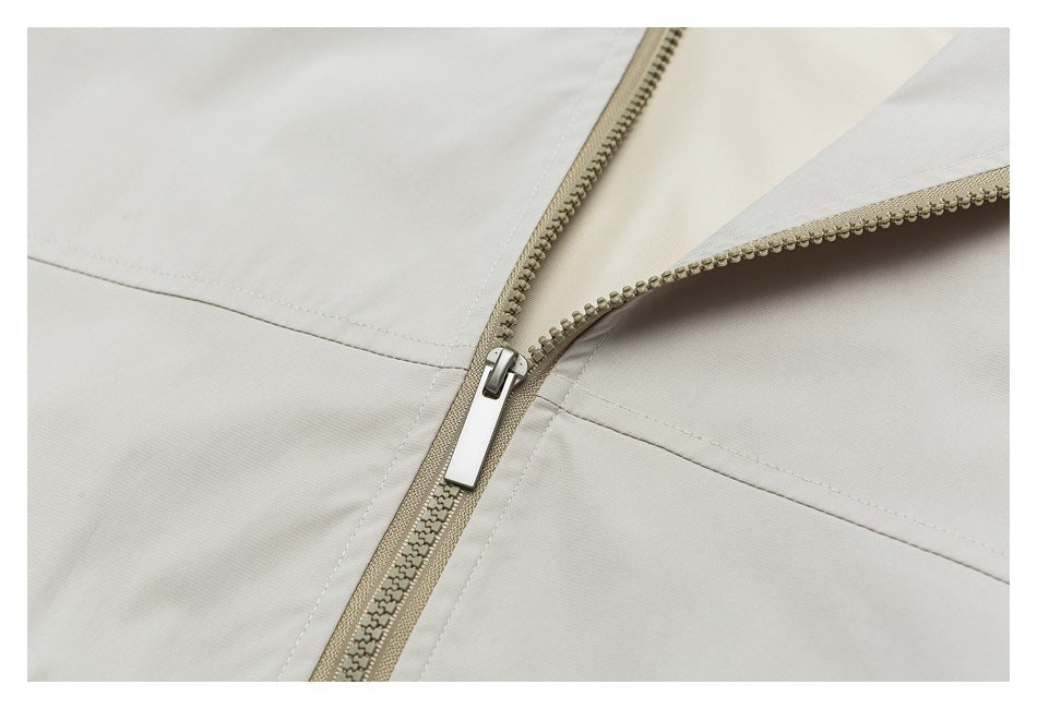 Close-up of a beige garment's partially opened zipper and stitched panels.