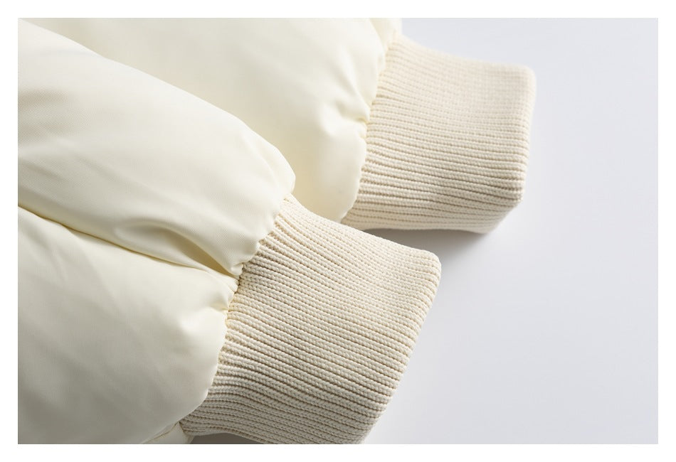 Close-up of two thick rib-knit cuffs attached to pale cream sleeves.
