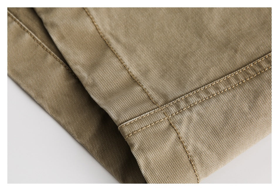 Close-up of tan trouser fabric and a neatly double-stitched hem.