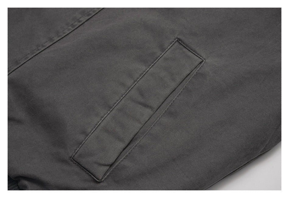 Close-up of a narrow welt pocket on charcoal jacket fabric.