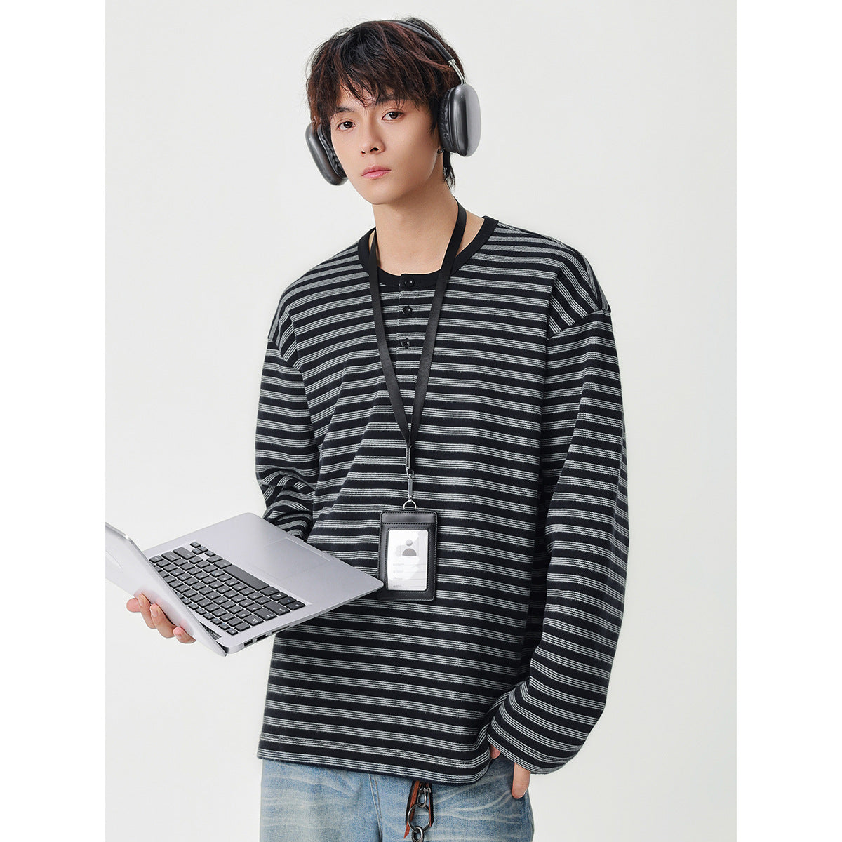 Model wearing a black and gray striped long-sleeve henley with a button placket.