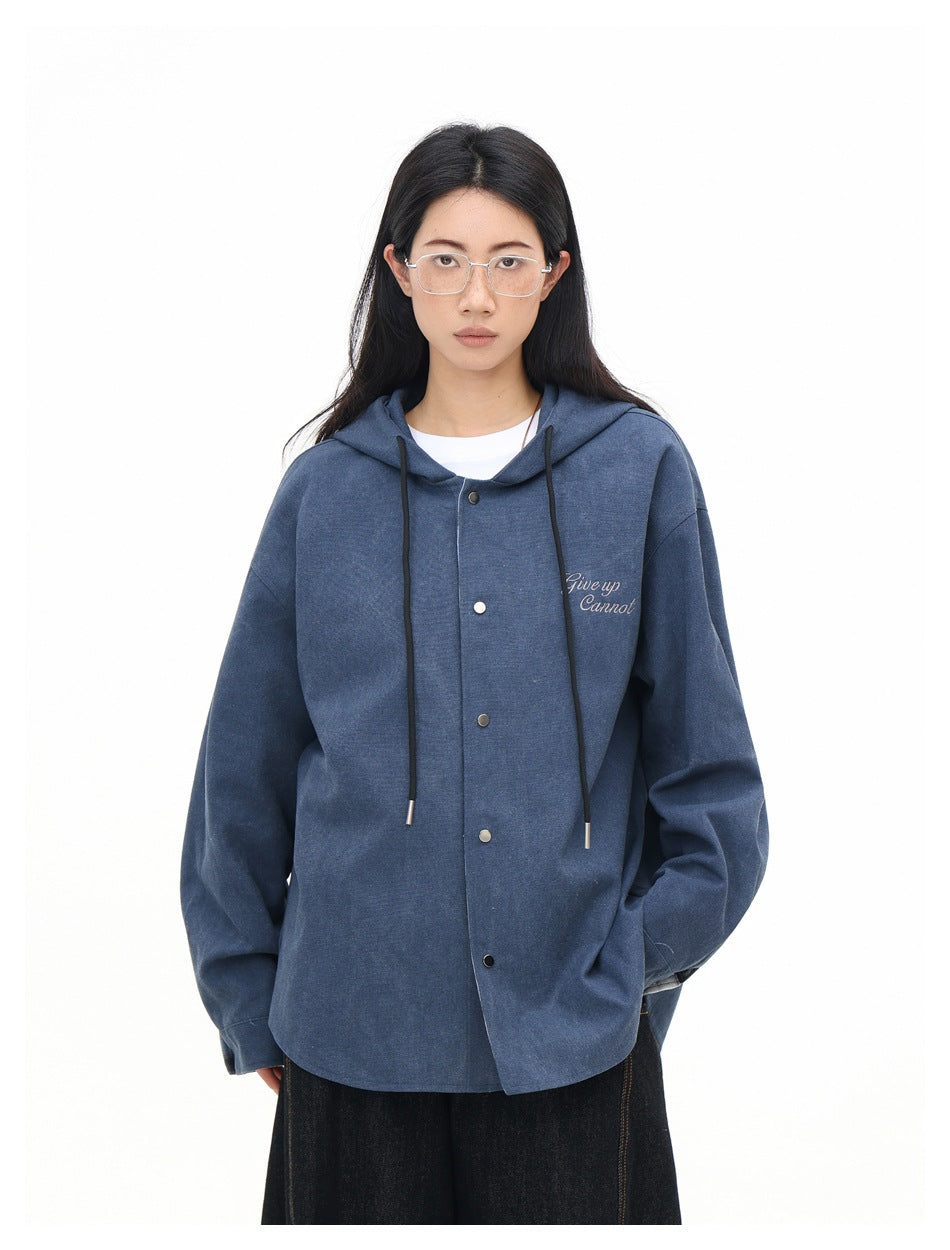 Front view of a model wearing a solid blue hooded button-front jacket with black drawstrings and small chest lettering.