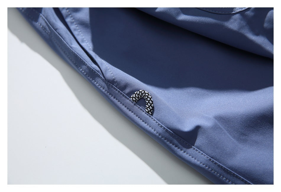 Close-up of a black-and-white braided loop beside the stitched edge of blue shorts.