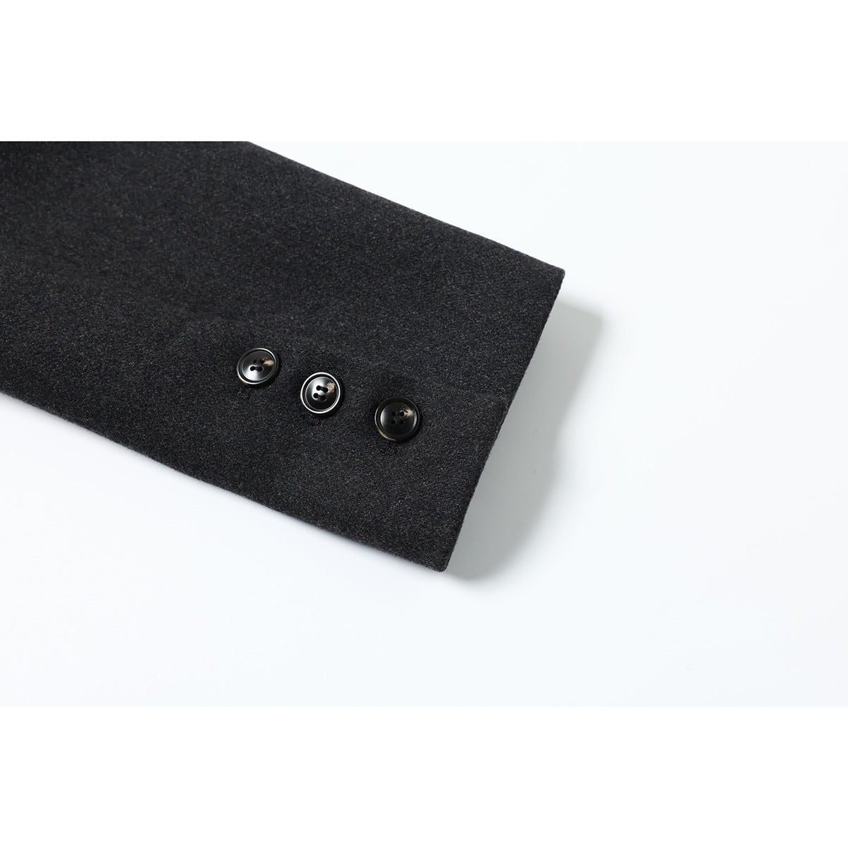 Charcoal gray coat sleeve cuff with three dark buttons.