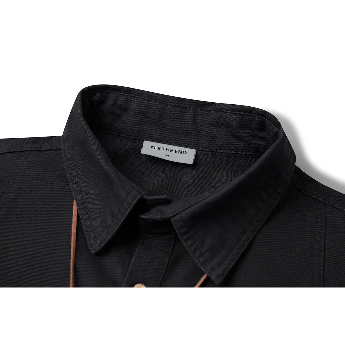 Close-up of a black shirt's pointed collar, stitching, and sewn-in neck label.