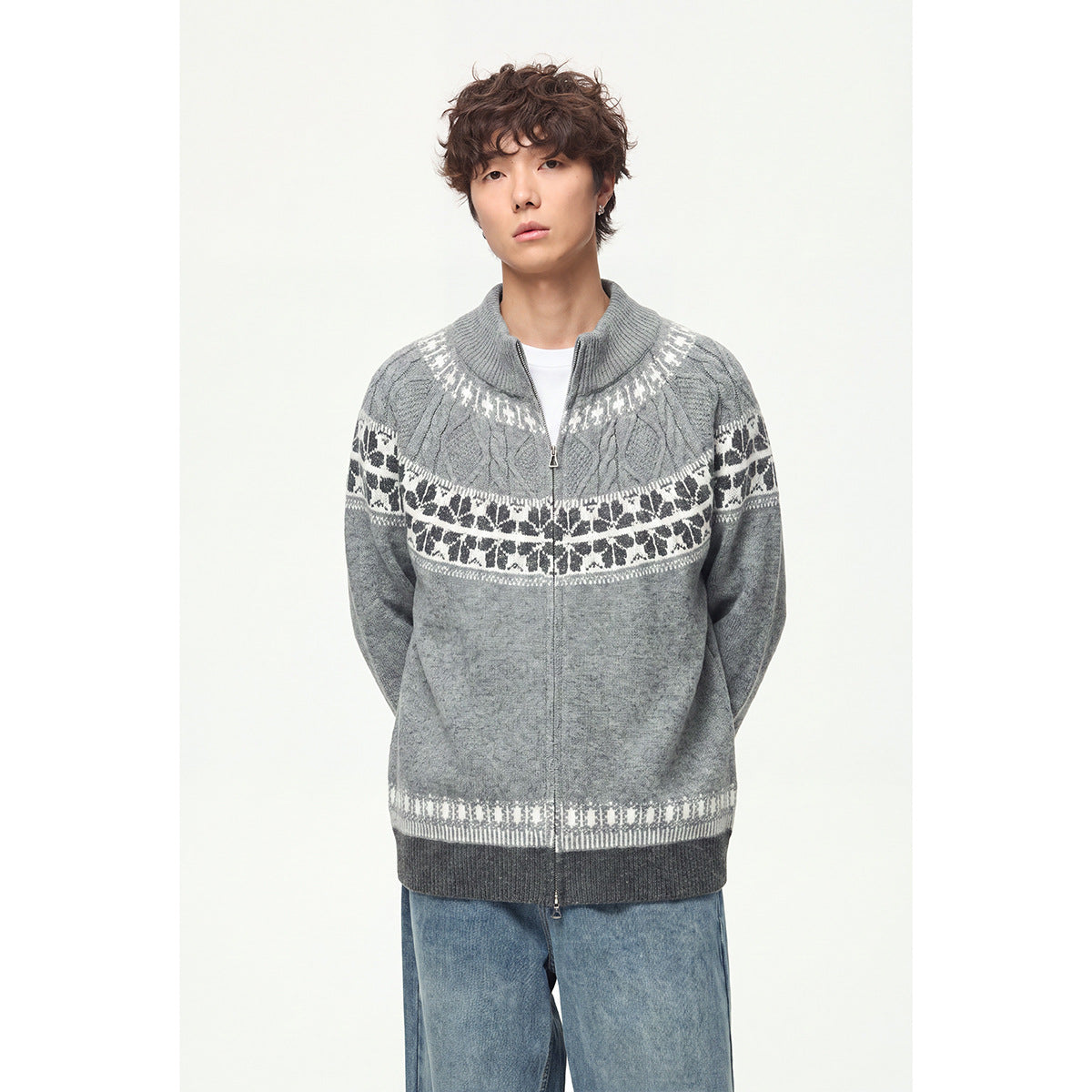 Model standing in a light gray zip-up knit cardigan with white and dark patterned bands and dark gray ribbed trim.