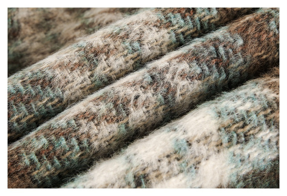 Close-up of layered folds showing the coat's fuzzy brown, cream, and muted teal patterned fabric.