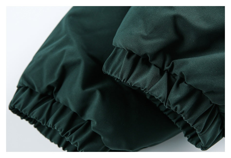Close-up of gathered elastic hems on dark green garment fabric.