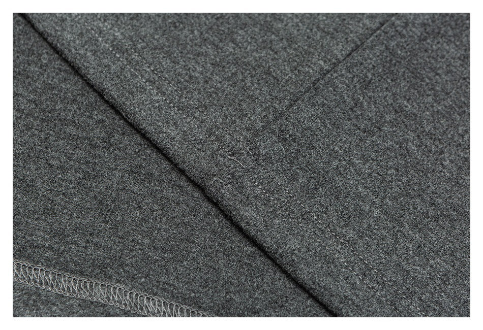 Close-up of dark gray fabric with a diagonal stitched seam and overlocked edge.