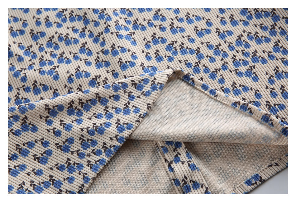 Close-up of beige ribbed floral fabric folded back to show its plain reverse side.