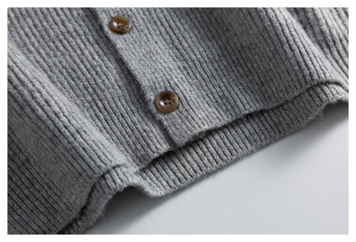 Close-up of the gray cardigan's button placket and ribbed hem.