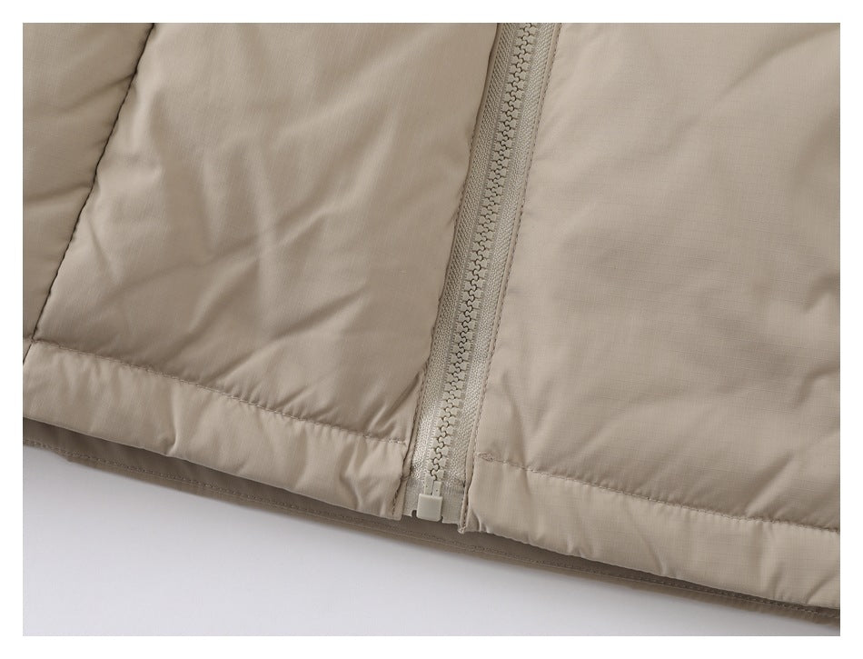 Close-up of the taupe jacket's front zipper and bottom hem.