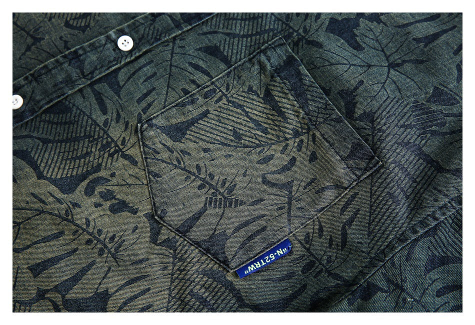 Close-up of the shirt's angled chest pocket, white buttons, and dark leaf print.
