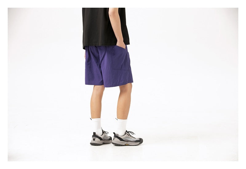 Model wearing purple shorts, shown from the back at a slight angle with a rear pocket visible.