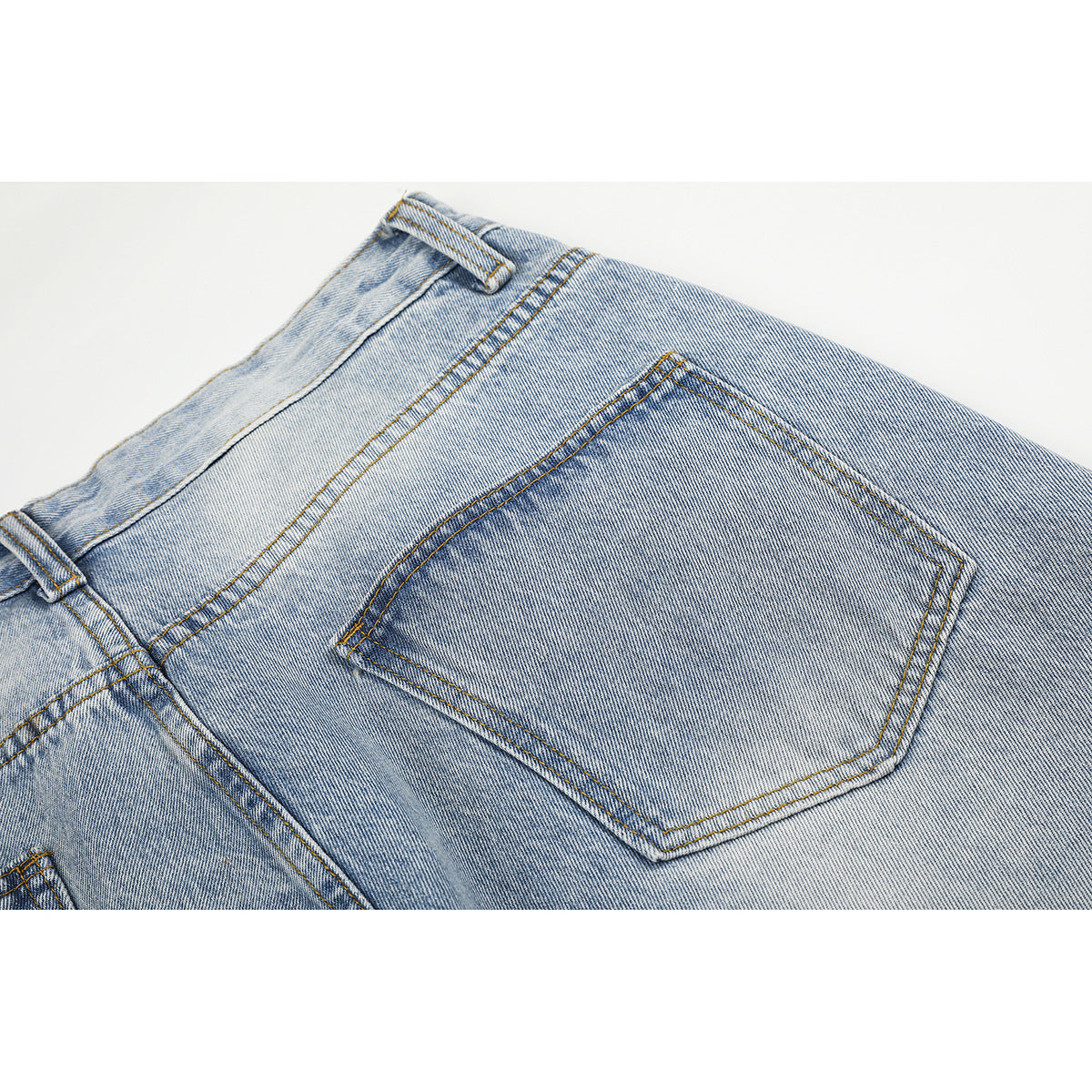 Close-up of the back of light-wash jeans, highlighting a patch pocket and contrast stitching.