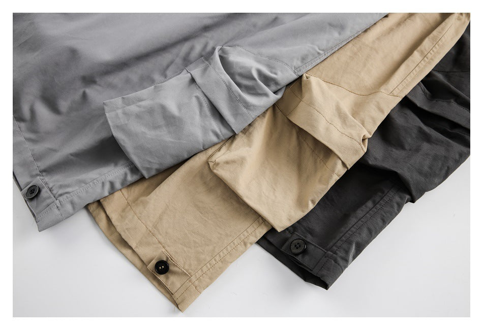 Overlapping gray, beige, and black pants show their lower legs and buttoned ankle cuffs.