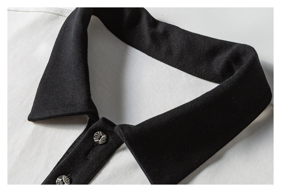 Close-up of a white polo shirt's black collar and button placket with metallic buttons.