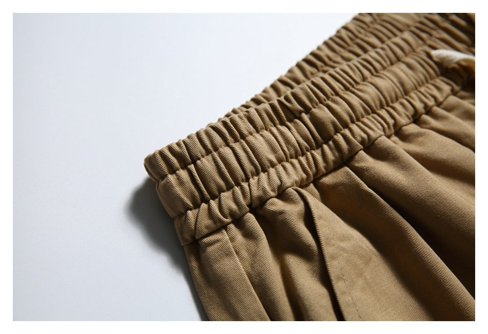 Close-up of the gathered elastic waistband on tan trousers.