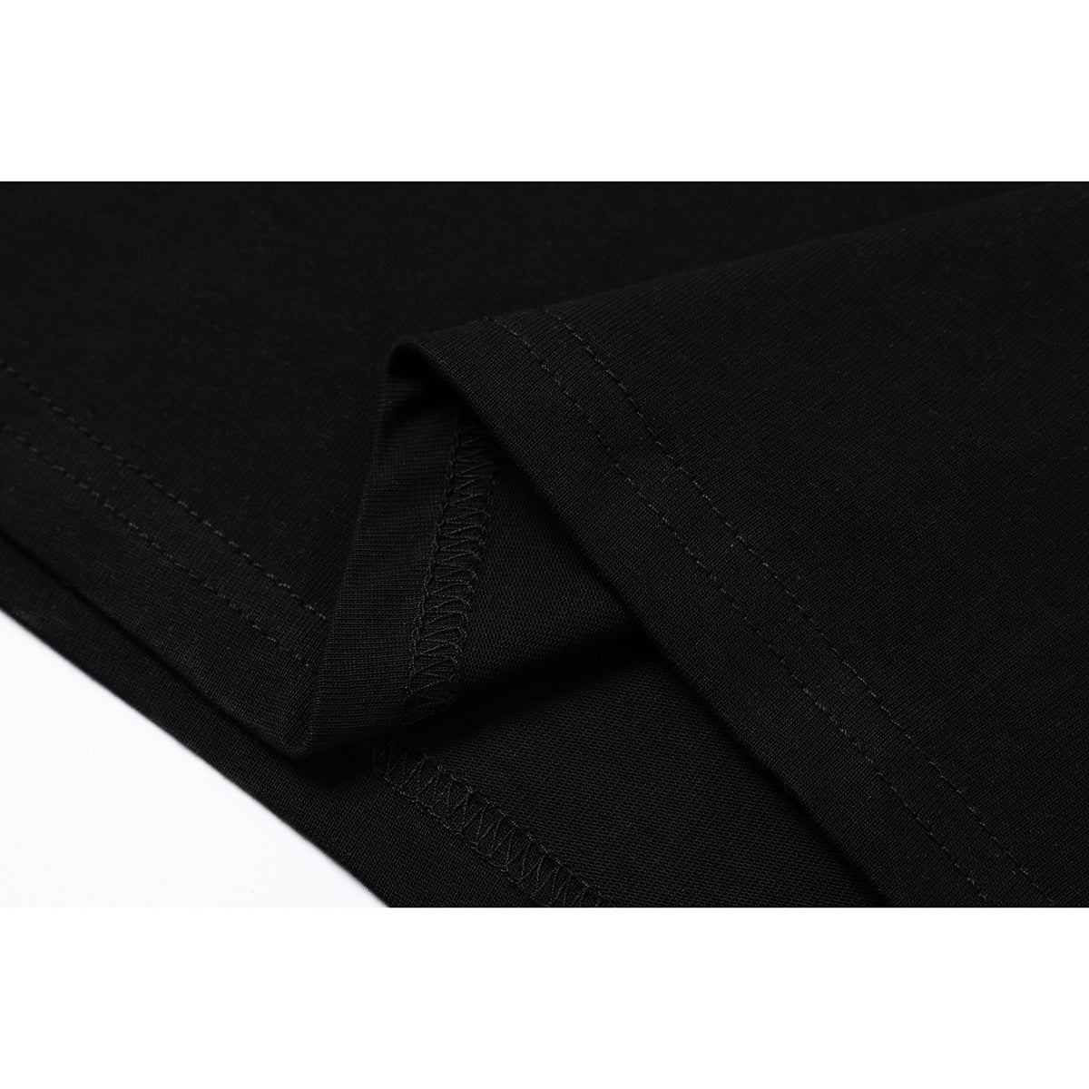 Close-up of the black T-shirt fabric and folded seam stitching.