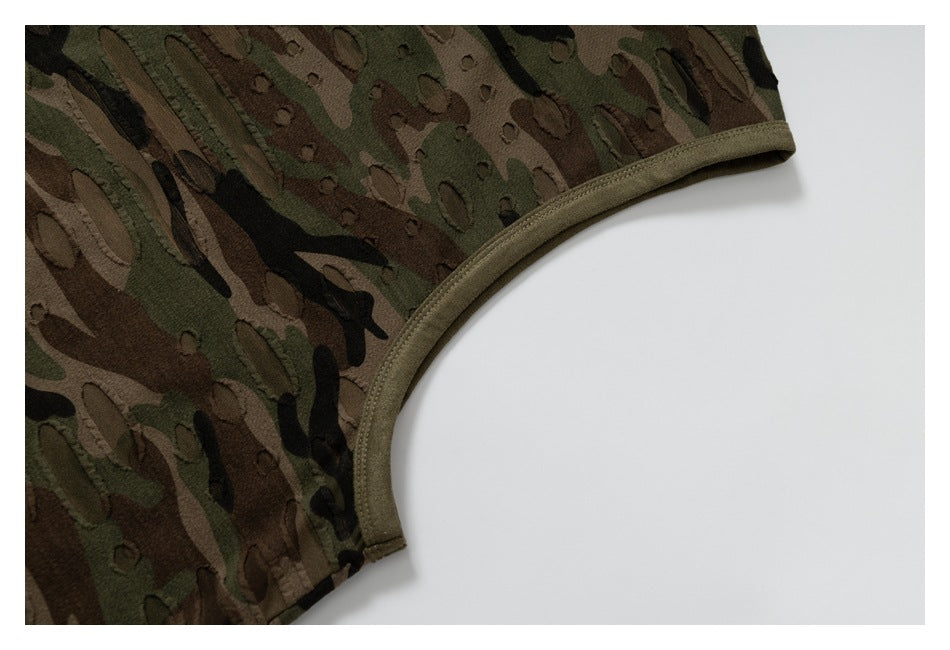 Close-up of the bound armhole and distressed olive, brown, and black camouflage fabric.