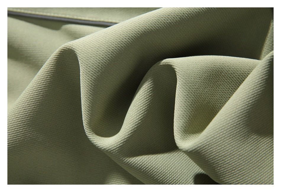 Extreme close-up of the textured sage green fabric folded into soft ridges.
