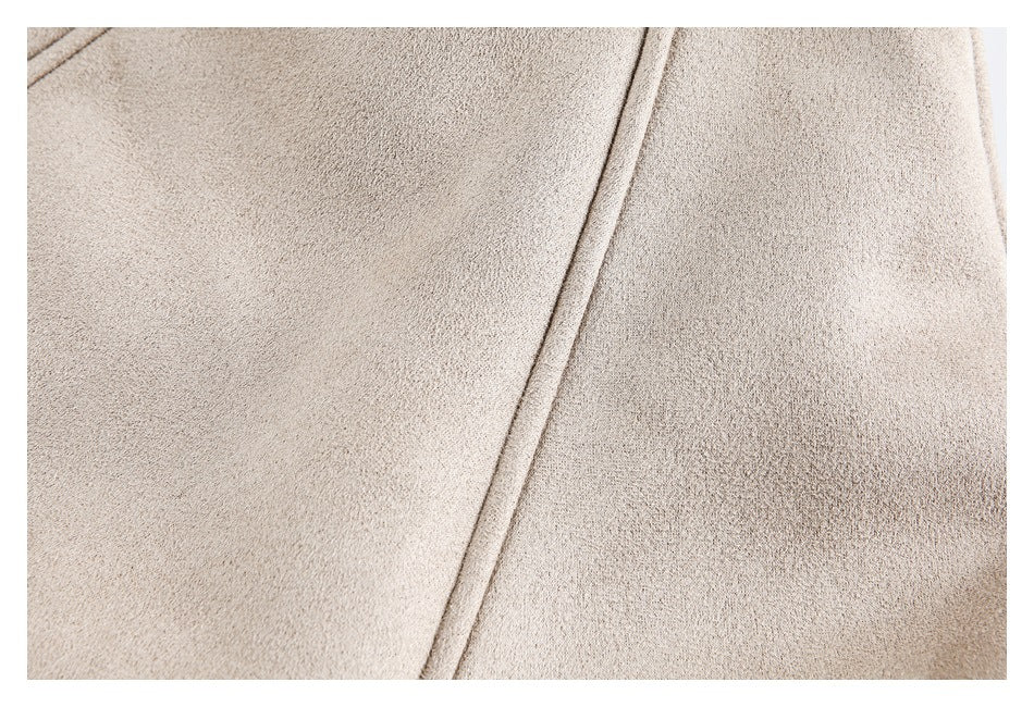 Close-up of beige garment fabric with a diagonal stitched seam.
