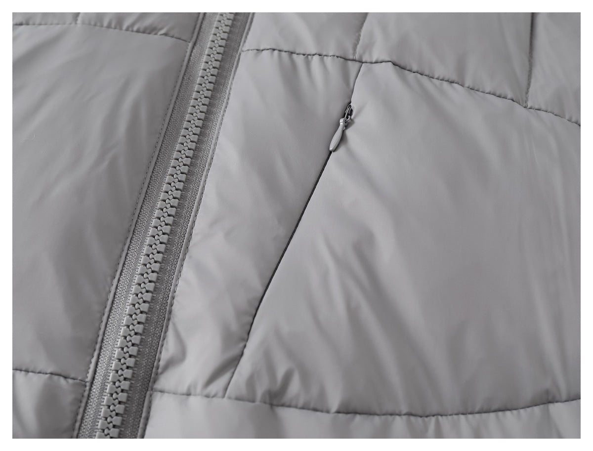 Close-up of a gray padded jacket with a chunky front zipper and a small angled zip pocket.