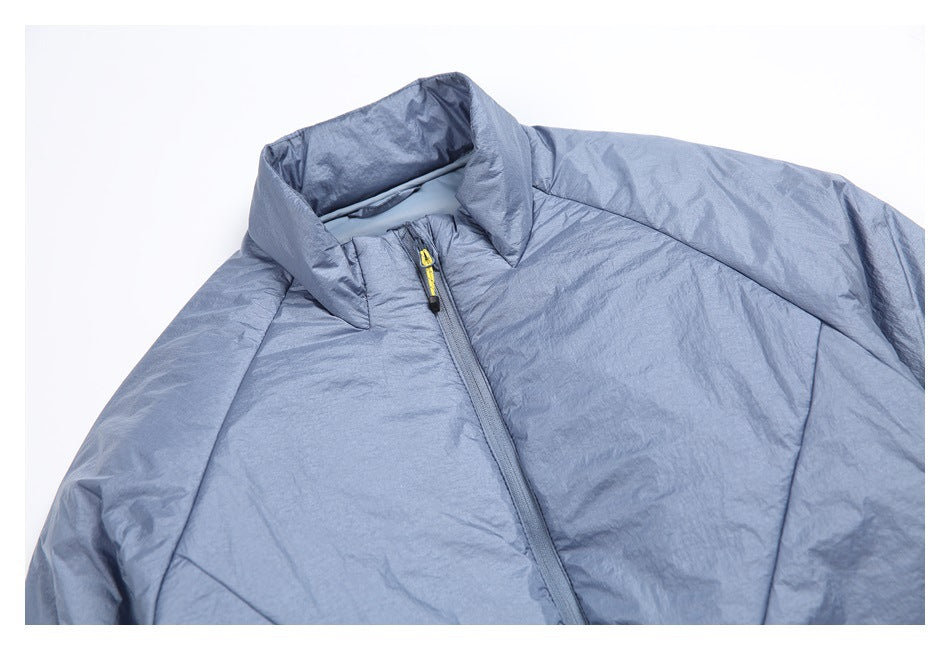 Close-up of a pale blue jacket's stand collar, front zipper with a yellow pull, and stitched panels.