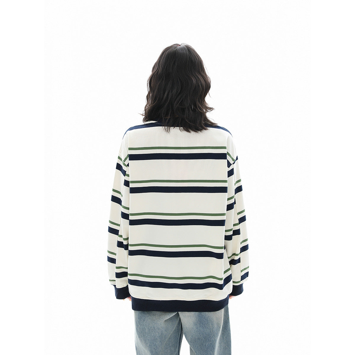 Rear view of a model wearing an ivory shirt with navy and green horizontal stripes and dark ribbed cuffs and hem.
