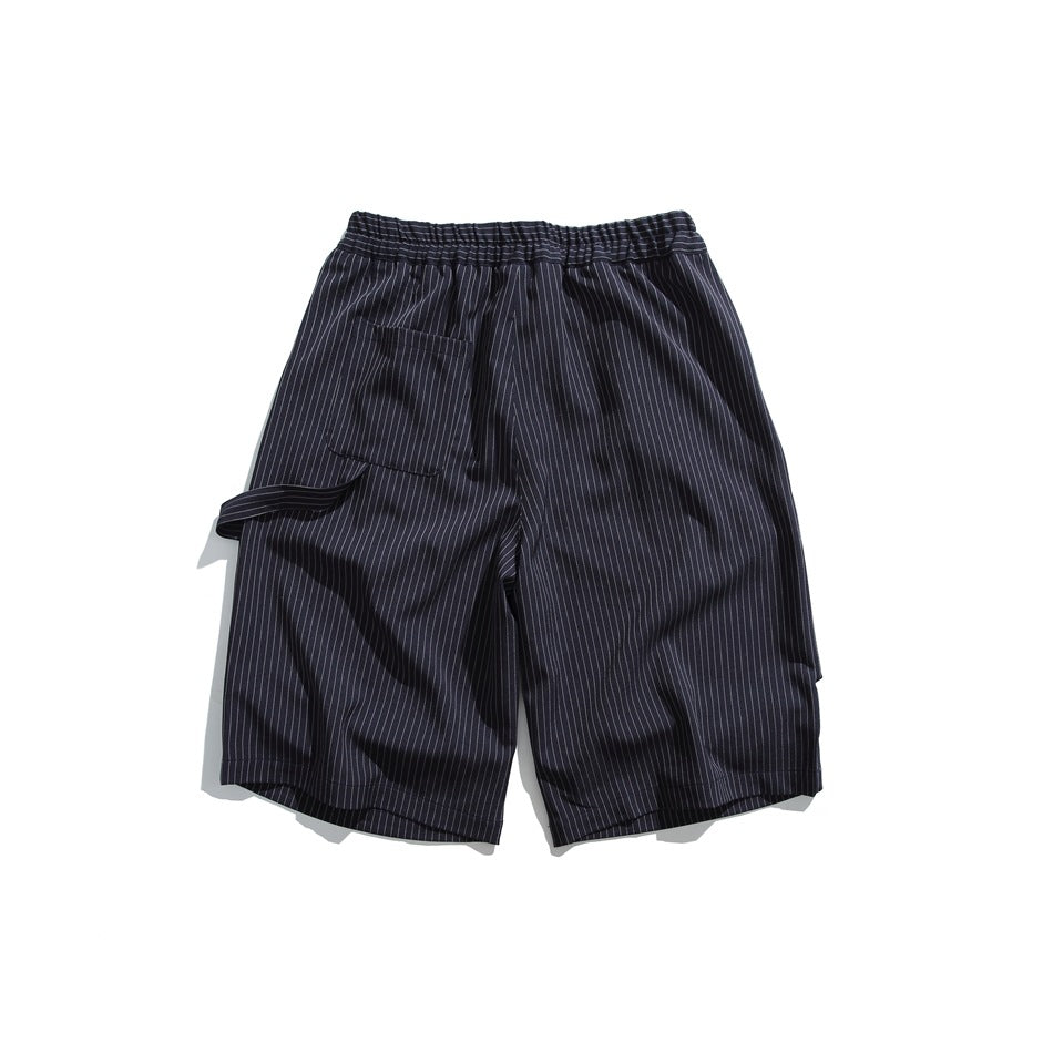 Back view of dark navy pinstripe shorts with an elasticated waistband, a patch pocket and a fabric side tab.