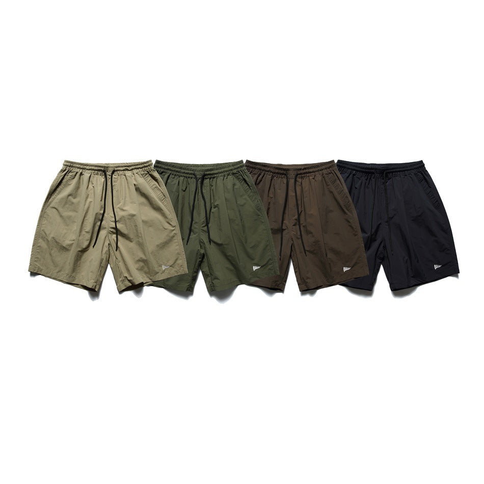 Four pairs of drawstring shorts shown together in khaki, olive green, brown and black.