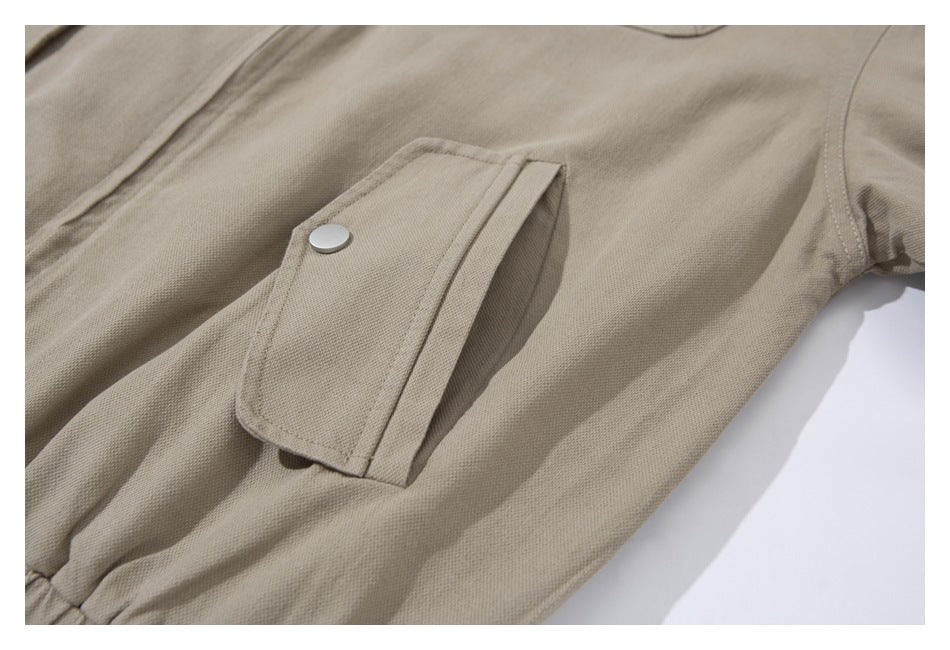 Close-up of a tan jacket pocket with a snap-fastened flap.