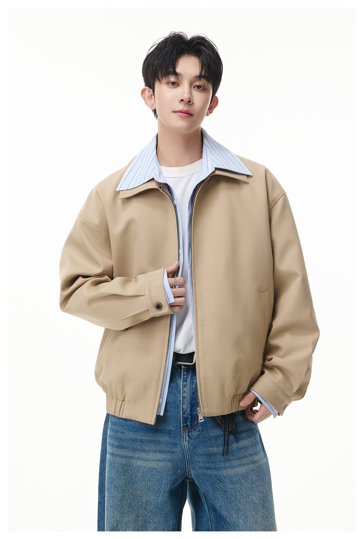 Model wearing a beige relaxed-fit jacket with a wide collar, zip front, and blue jeans.