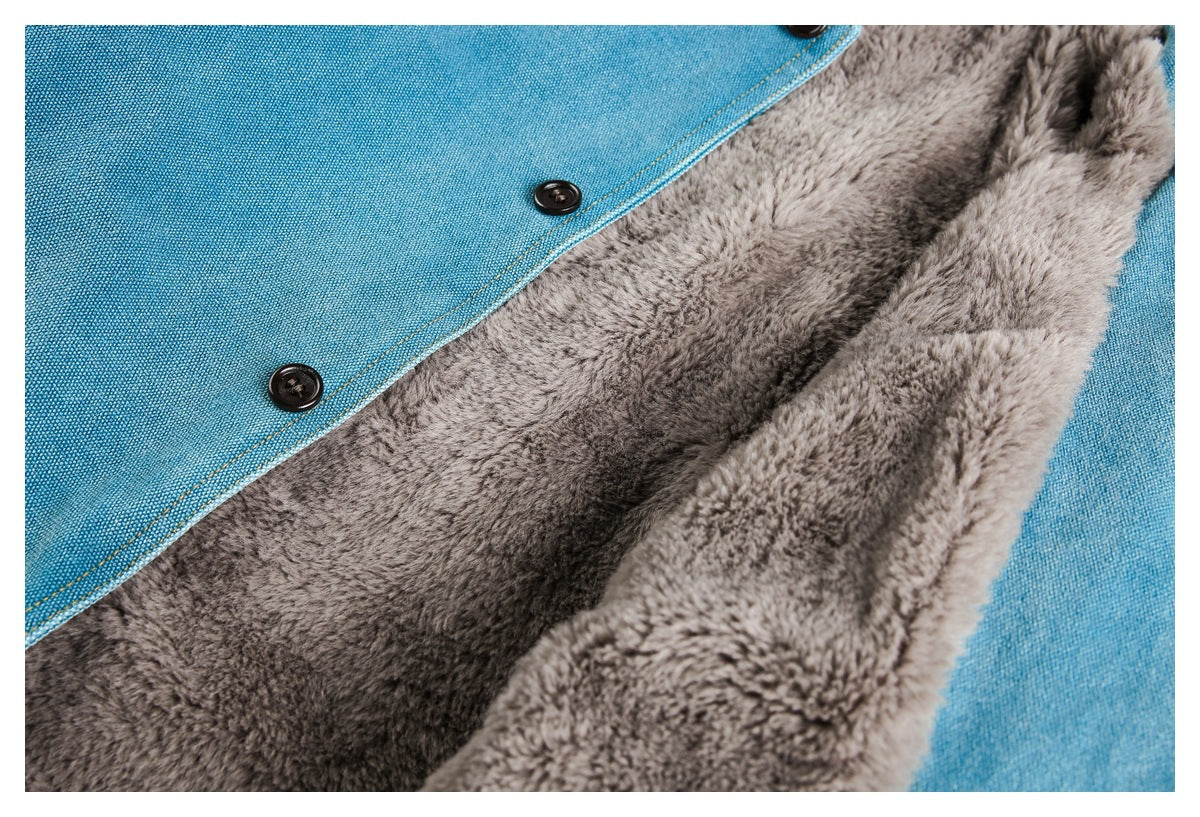 Close-up of a teal jacket opened to show thick gray plush lining, black buttons, and stitched edges.
