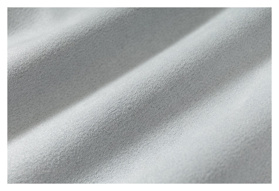 Extreme close-up of the light gray fabric surface and its fine texture.