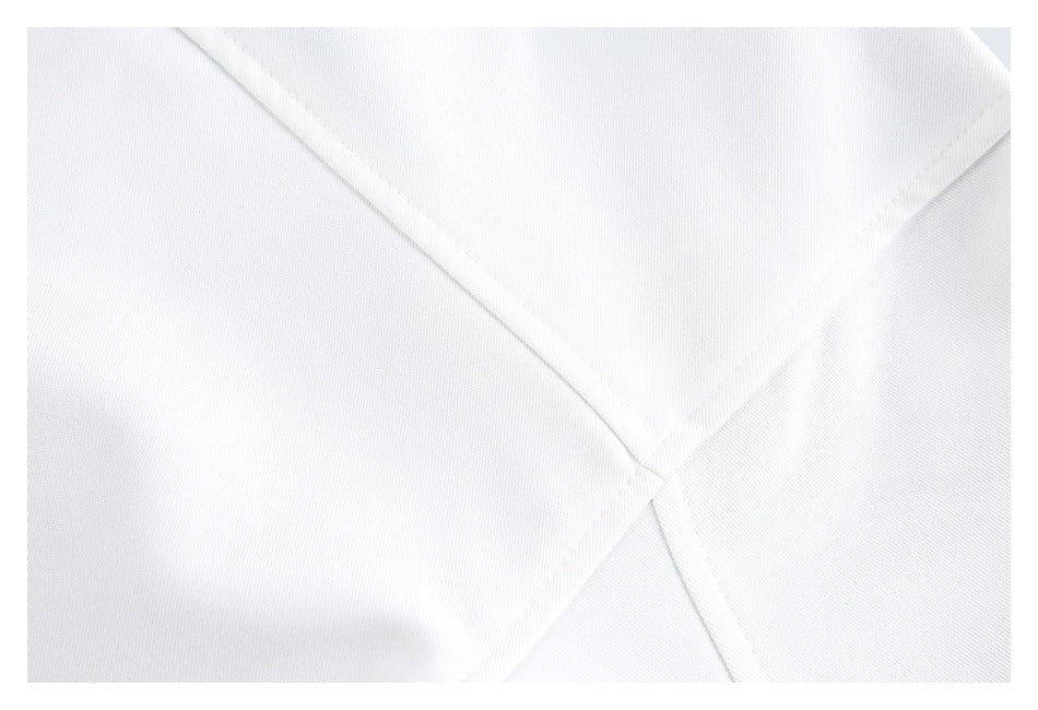 Close-up of intersecting stitched seams on white garment fabric.