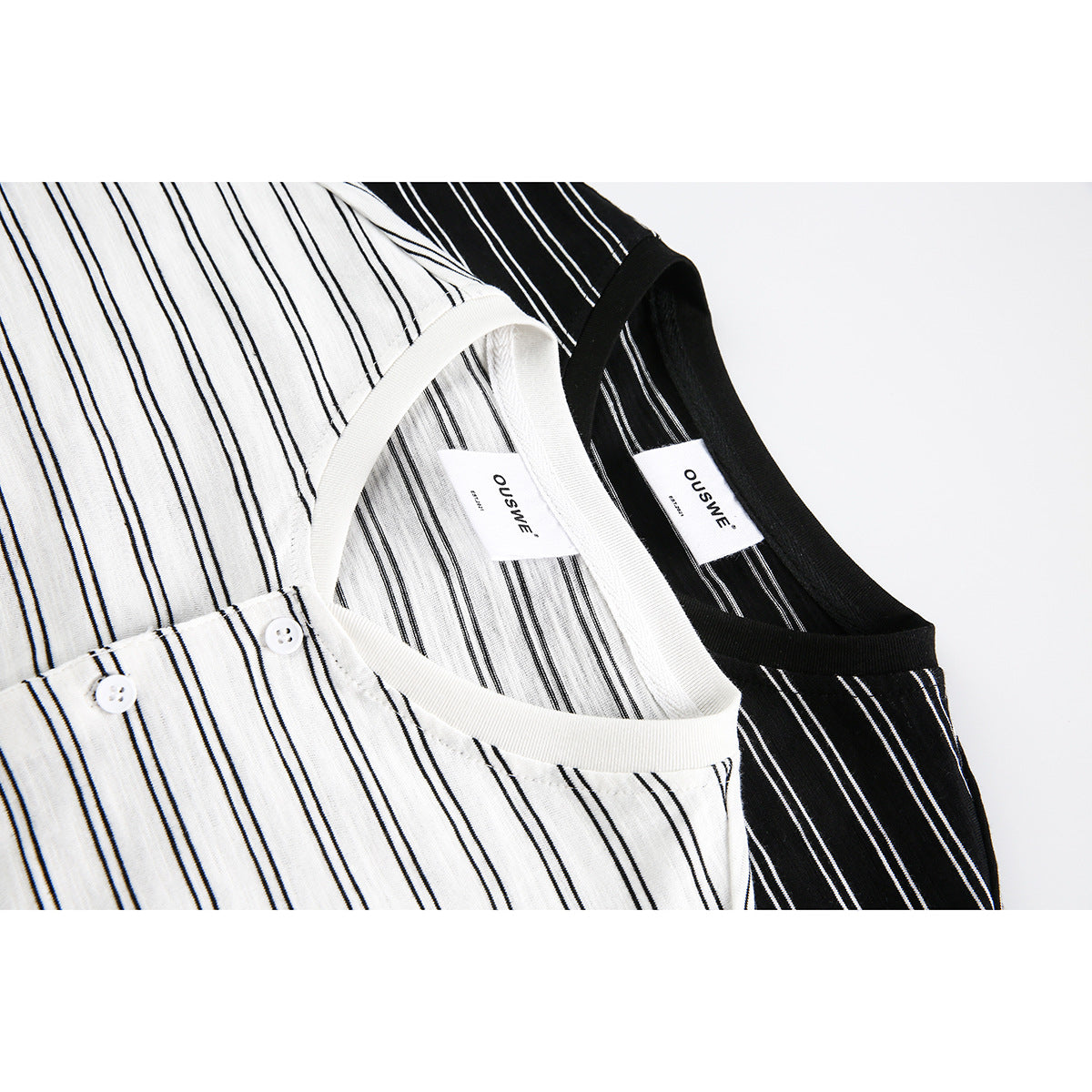 Close-up of white and black striped shirts showing their V-neck trim, labels and button plackets.