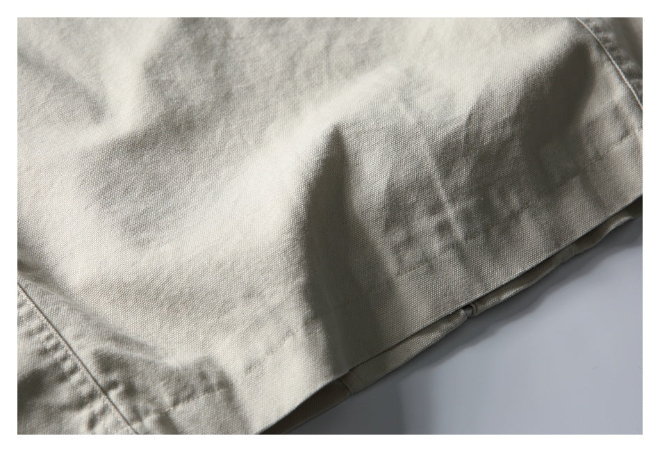 Close-up of the hem and seam on a light beige textured garment.