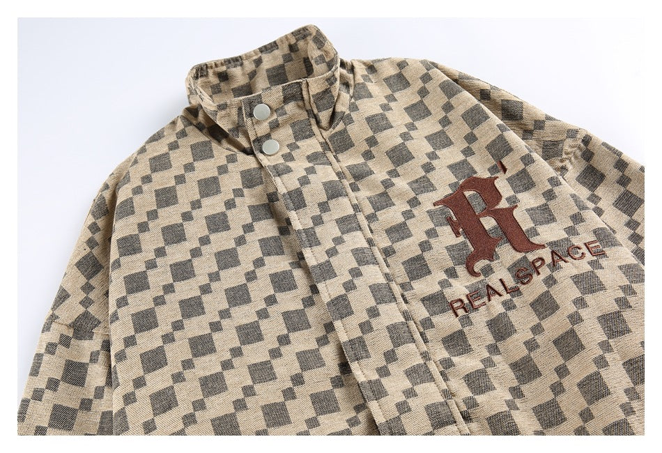 Close-up of the jacket front showing its checker pattern, snap-button collar, and brown embroidered emblem and text.