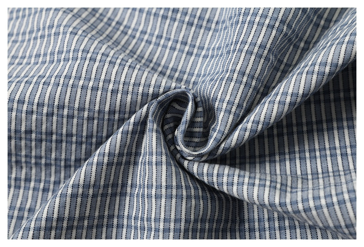 Close-up of blue-and-white striped garment fabric gathered into a soft twist.