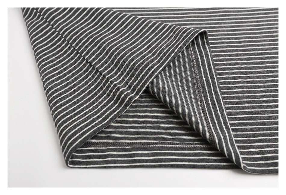Close-up of the charcoal gray and white striped shirt hem folded back to show the stitching.