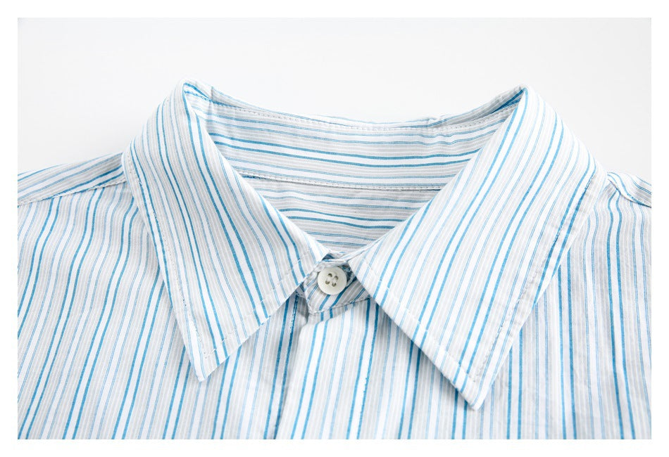 Close-up of a pointed collar and top button on a blue-and-white striped shirt.